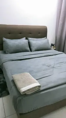 a bed with a blanket and pillows on it at KhyraHomestay in Kampong Ayer Melintas Besar