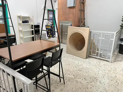 a laundry room with a washing machine and a table and chairs at Hippo House Taiping in Taiping