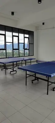 a row of ping pong tables in a room with windows at DeRose Homestay, Pekan Ipoh in Ipoh
