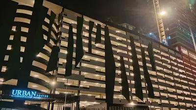 a large building with a sign on it at night at VIP3BR Romantic Retreat for12 withSea & City Views in Jelutong