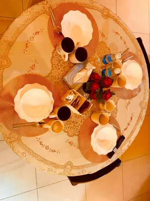 a table with plates and cups and flowers on it at Stunning Sea & City View Apartment in George Town in Jelutong
