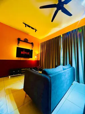a living room with a blue couch and a ceiling fan at Spacious3BR 12-PaxApartmentStunning Sea &CityViews in Jelutong