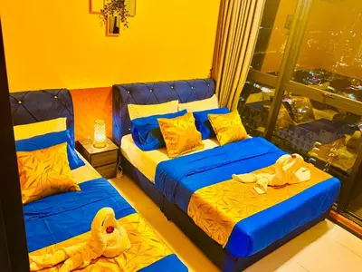 two beds in a hotel room with towels on them at Deluxe Suites with Infinity Pool, Kids' Pool & Sea in Jelutong