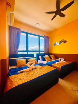 a bedroom with two beds with people laying on them at Deluxe Suite for10 Stunning Sea &City ViewsNetflix in Jelutong