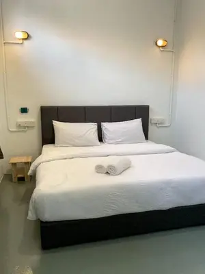 a large bed with white sheets and two towels on it at 39 Love Lane - Smart Intelligent Inn Georgetown in George Town