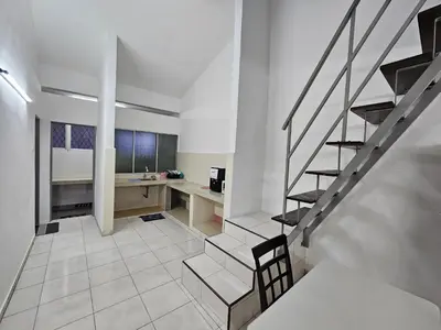 a room with a staircase and a desk in it at Rain Forest Hostel in Ipoh