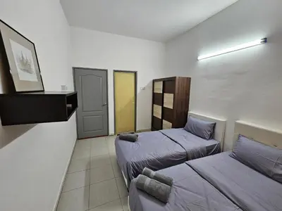 a room with two beds and a tv in it at Rain Forest Hostel in Ipoh