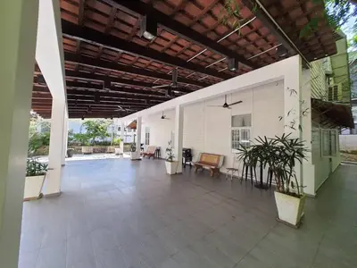 an empty lobby of a building with benches and plants at Lisa Countryside Homestay in Ayer Tawar