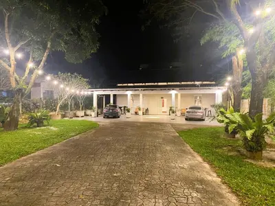 a house at night with cars parked in the driveway at Lisa Countryside Homestay in Ayer Tawar