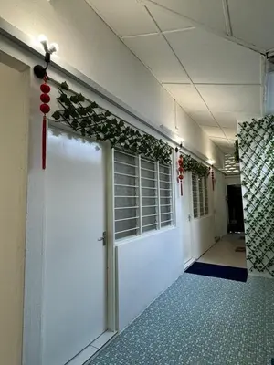 a hallway with a white door with a green garland at Yipstay Gopeng HomeTown in Gopeng
