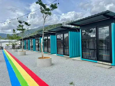 a rainbow colored building with a tree in front of it at The Cozytainer in Taiping