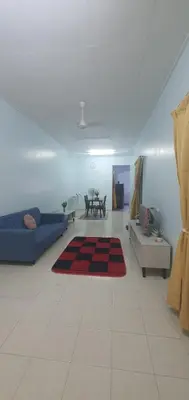 a living room with a blue couch and a red rug at Chill Spot Homestay in Ipoh