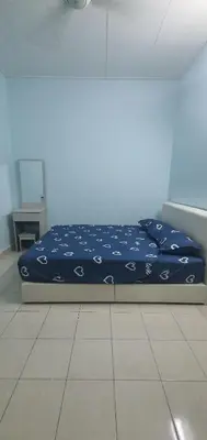 a bedroom with a bed with a blue comforter at Chill Spot Homestay in Ipoh