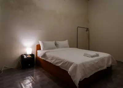 a bed in a room with a lamp on a table at Aayu Pantai - George Town, Penang in George Town