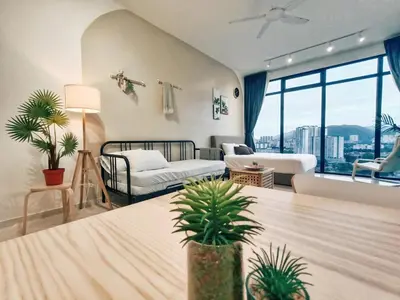 a living room with two beds and potted plants at 8Pax City Centre 2BR 3km to Komtar in George Town