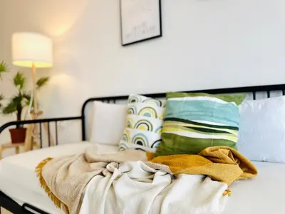 a bed with a pile of blankets and pillows at Comfy 2BR Sunny Suite Sky Pool & Stunning Views in George Town