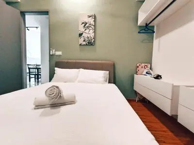 a bedroom with a large white bed and a cabinet at Haven Luxury 2BR Suite with Stunning Views in George Town
