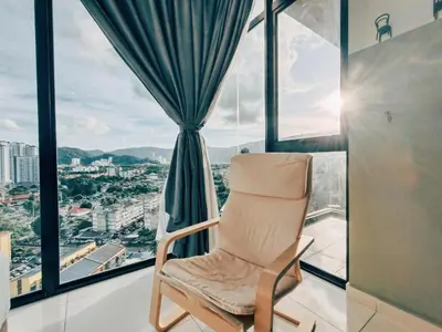 a chair sitting in a room with a window at Haven Luxury 2BR Suite with Stunning Views in George Town