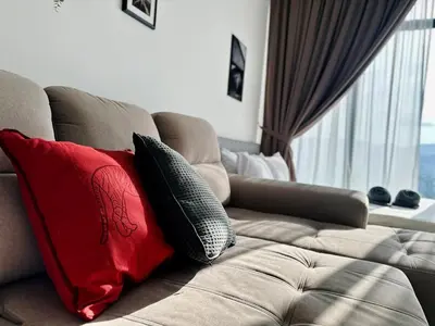 a couch with two pillows on it in a living room at Luxury 2BR SunnySuite Sky Pool Breathtaking Views in George Town
