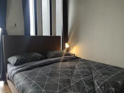 a bedroom with a bed with a black comforter and a window at Luxury Sky Pool 8-Pax City Centre Beacon in George Town