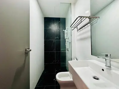 a bathroom with a sink and a toilet and a mirror at Spacious 2BR Suite for 5-7 pax in George Town