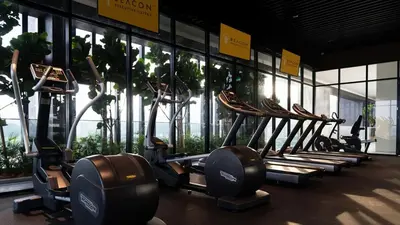 a row of treadmills in a gym with windows at Stunning 2BR with Infinity Pool & City Views in George Town