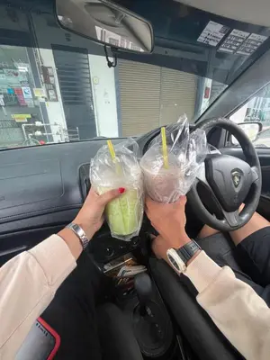 a person sitting in a car holding two drinks at Muhammad Najmi Hakim Bin Abdullah in Kampar