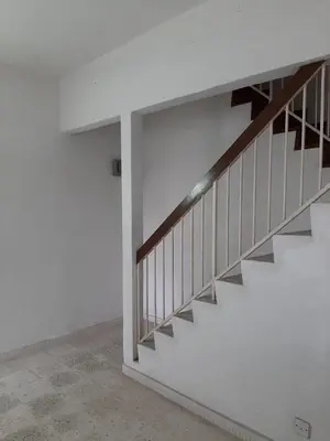 a staircase in a room with white walls at Rumah Teres Teluk Kumbar in Bayan Lepas