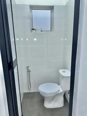 a white bathroom with a toilet and a window at Urban Eats Stay in Ipoh