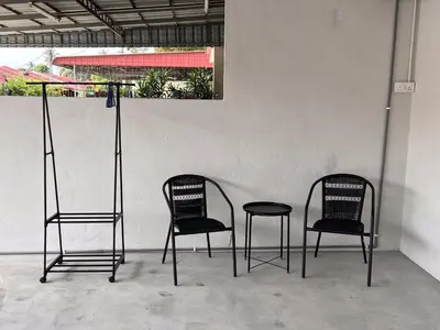 three black chairs sitting next to a wall at Urban Eats Stay in Ipoh