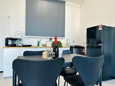 a kitchen with a table with chairs and a refrigerator at World Class Apartment In Georgetown 3BR 10pax in Jelutong