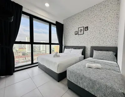 a bedroom with two beds and a large window at World Class Apartment In Georgetown 3BR 10pax in Jelutong