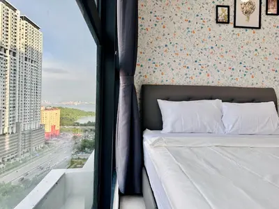 a bedroom with a bed with a view of a city at World Class Apartment In Georgetown 3BR 10pax in Jelutong