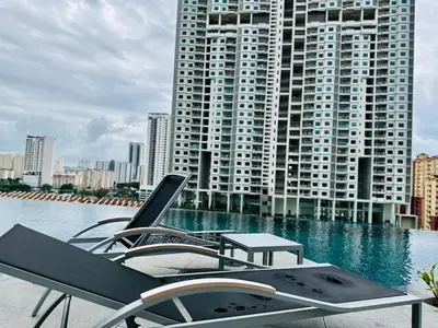 a pool with chairs and a table and a building at Familystay Home 3BR-10PAX Urban suites in George Town