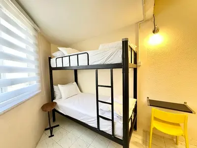 two bunk beds in a room with a yellow chair at Bahari 58 in George Town