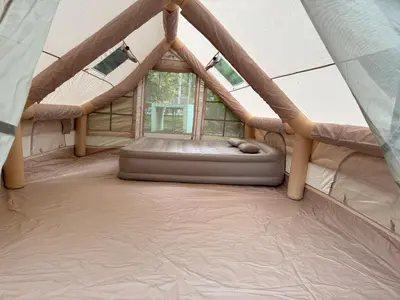 a bed in a tent with a window at Glamping in Tapah