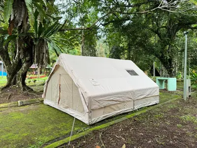 a tent sitting in the grass under a tree at Glamping in Tapah