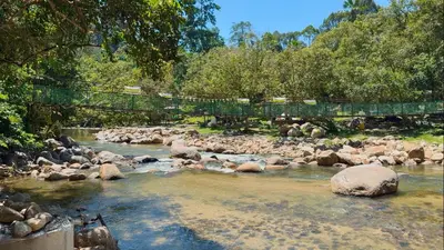 a river with rocks and a bridge over it at Glamping in Tapah