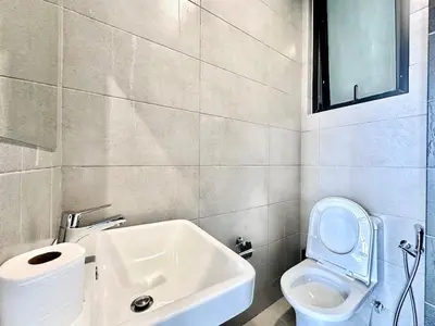 a bathroom with a white toilet and a sink at Charming Haven- Relaxing Retreat Nearby Airpor 10pax in George Town