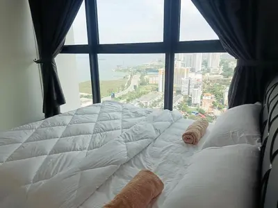 a bed in a room with a large window at Georgetown Komtar Familystay 3BR 10Pax in George Town