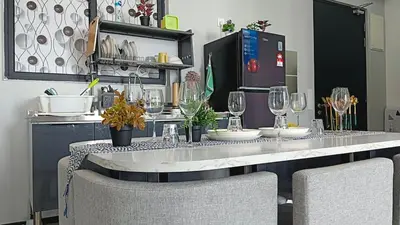 a table with chairs and wine glasses on it at Sea View Condo In Georgetown 10 pax in George Town