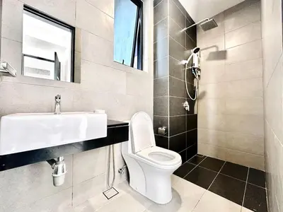 a bathroom with a sink and a toilet and a mirror at Sea View Condo In Georgetown 10 pax in George Town