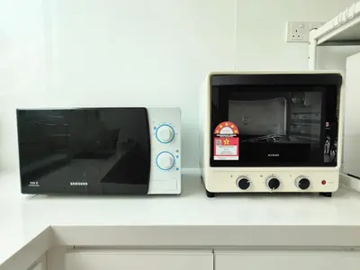 a microwave sitting on a counter next to a toaster oven at TheFloral Penthouse Night Market Wifi & Netflix in Brinchang