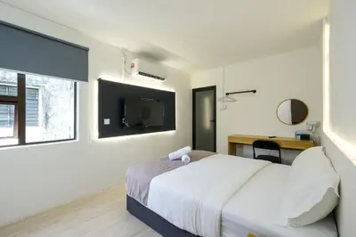 a bedroom with a bed and a desk and a tv at Loft 82 in Bukit Mertajam