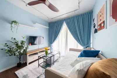 a bedroom with blue curtains and a bed and a tv at Royo Homestay in Palas Horizon in Brinchang