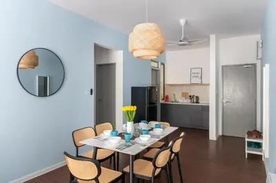 a dining room with a table with chairs and a mirror at Royo Homestay in Palas Horizon in Brinchang