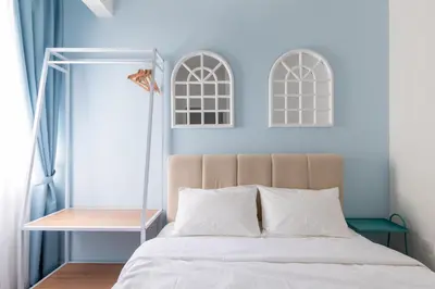 a bedroom with a bed with white sheets and a mirror at Royo Homestay in Palas Horizon in Brinchang