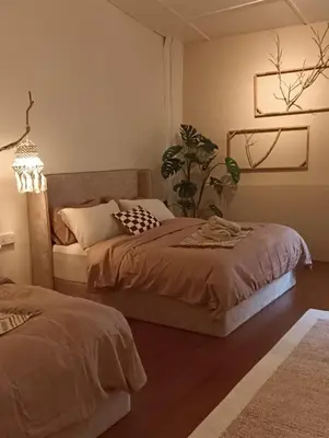 a bedroom with two beds and a plant at Senju Georgetown Heritage PrewarHouse 4BR 5-15 pax in George Town