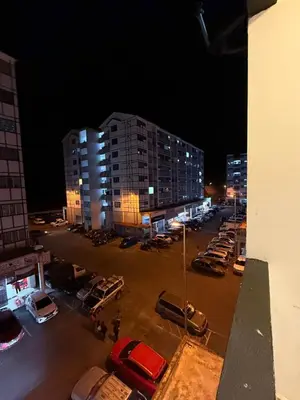 a parking lot with parked cars and buildings at night at AYAAN CLUB HOUSE Free WiFI & Netflix in Cameron Highlands