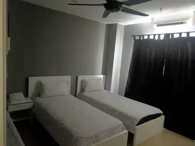 a bedroom with two beds and a ceiling fan at Champs elysees in Kampar